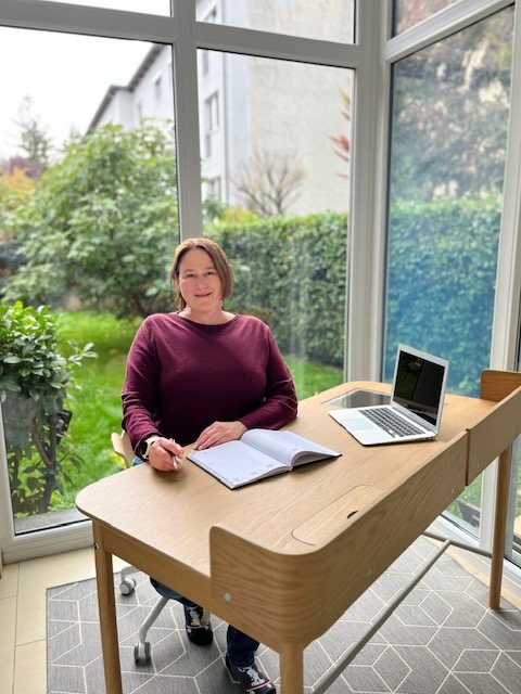 Barbara Fegerl bei der Arbeit mit Notizbuch und Laptop